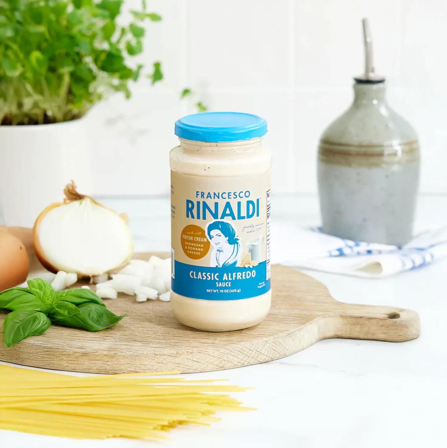 Jar of Francesco Rinaldi Classic Alfredo Sauce on cutting board.