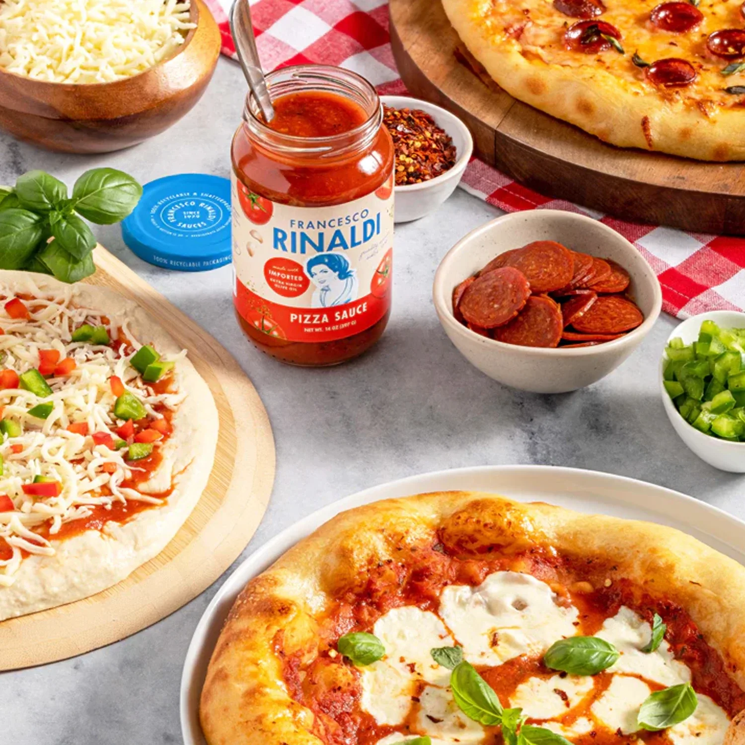 Jar of Francesco Rinaldi Pizza Sauce with homemade pizzas.