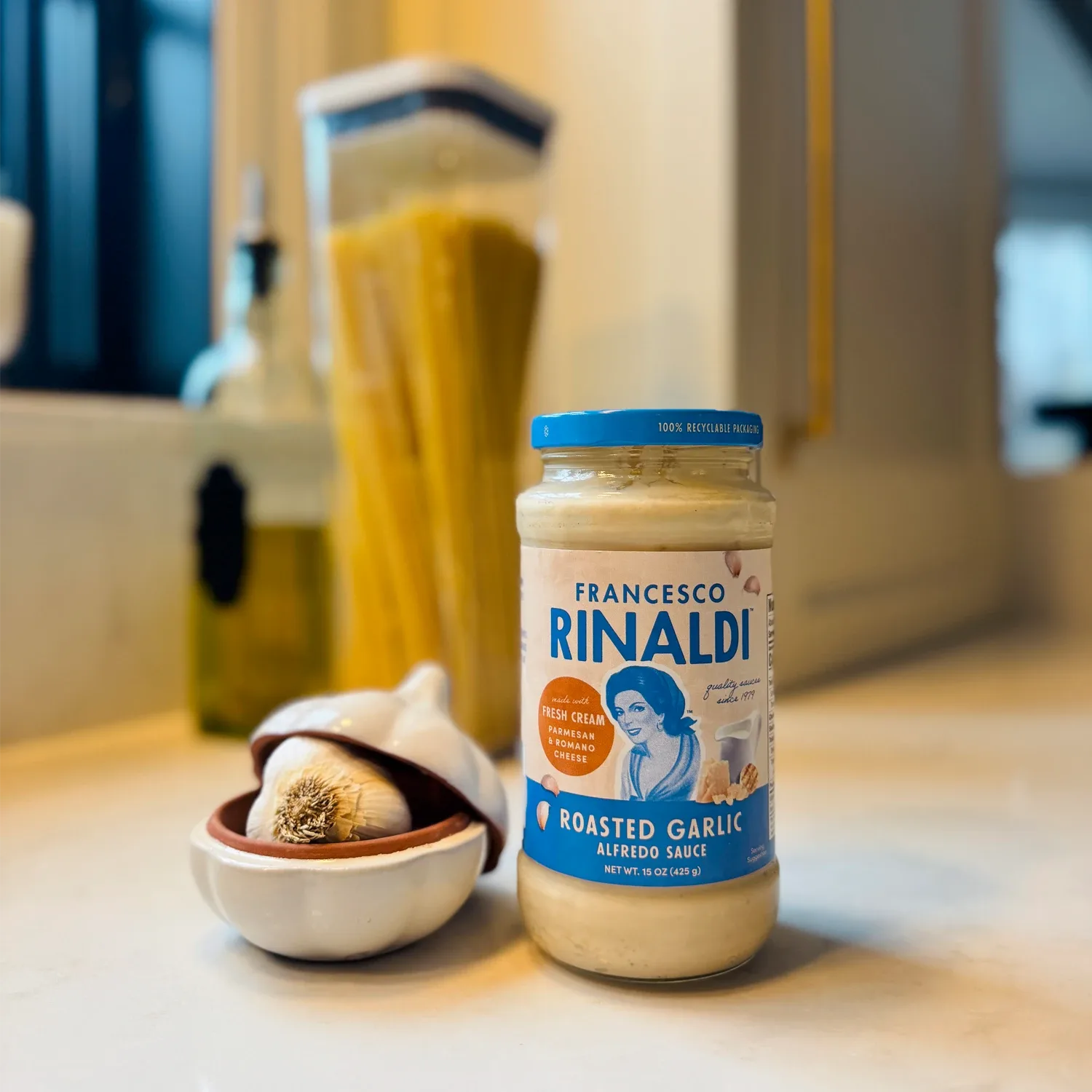 Jar of Francesco Rinaldi Roasted Garlic Alfredo Sauce next to fresh garlic.
