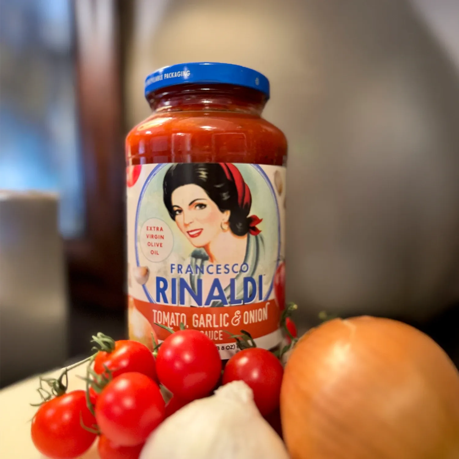 Jar of Francesco Rinaldi Tomato Garlic & Onion Sauce with produce.