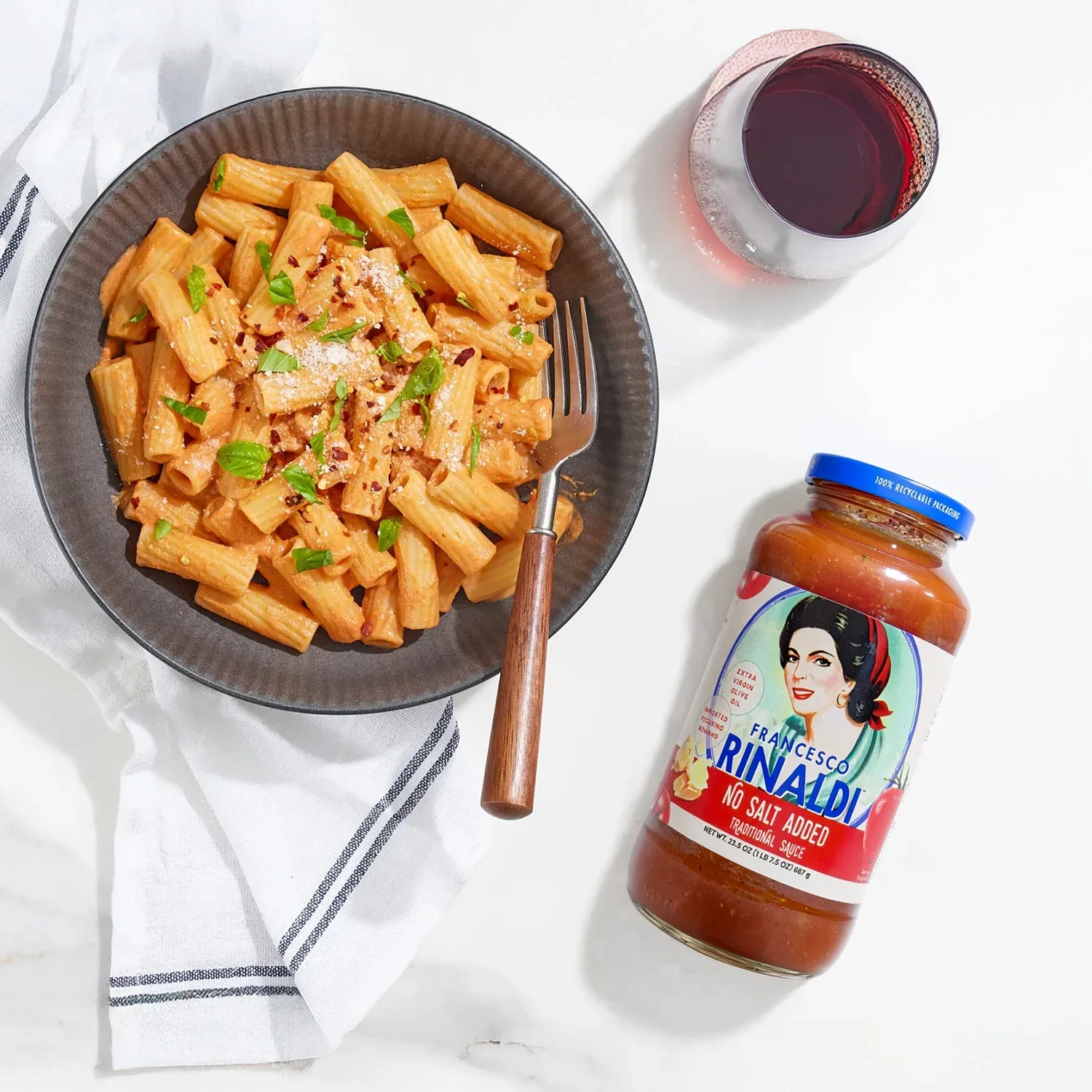 Overhead view of pasta dinner with jar of Francesco Rinaldi Sauce.