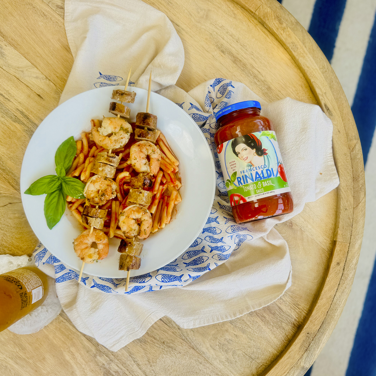 Francesco Rinaldi Tomato & Basil sauce and pasta alongside a dish of sausage and shrimp skewers.