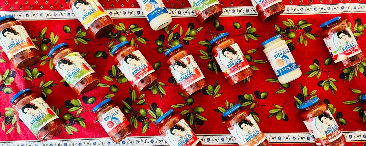 Overhead view of Francesco Rinaldi sauce jars on a tablecloth.