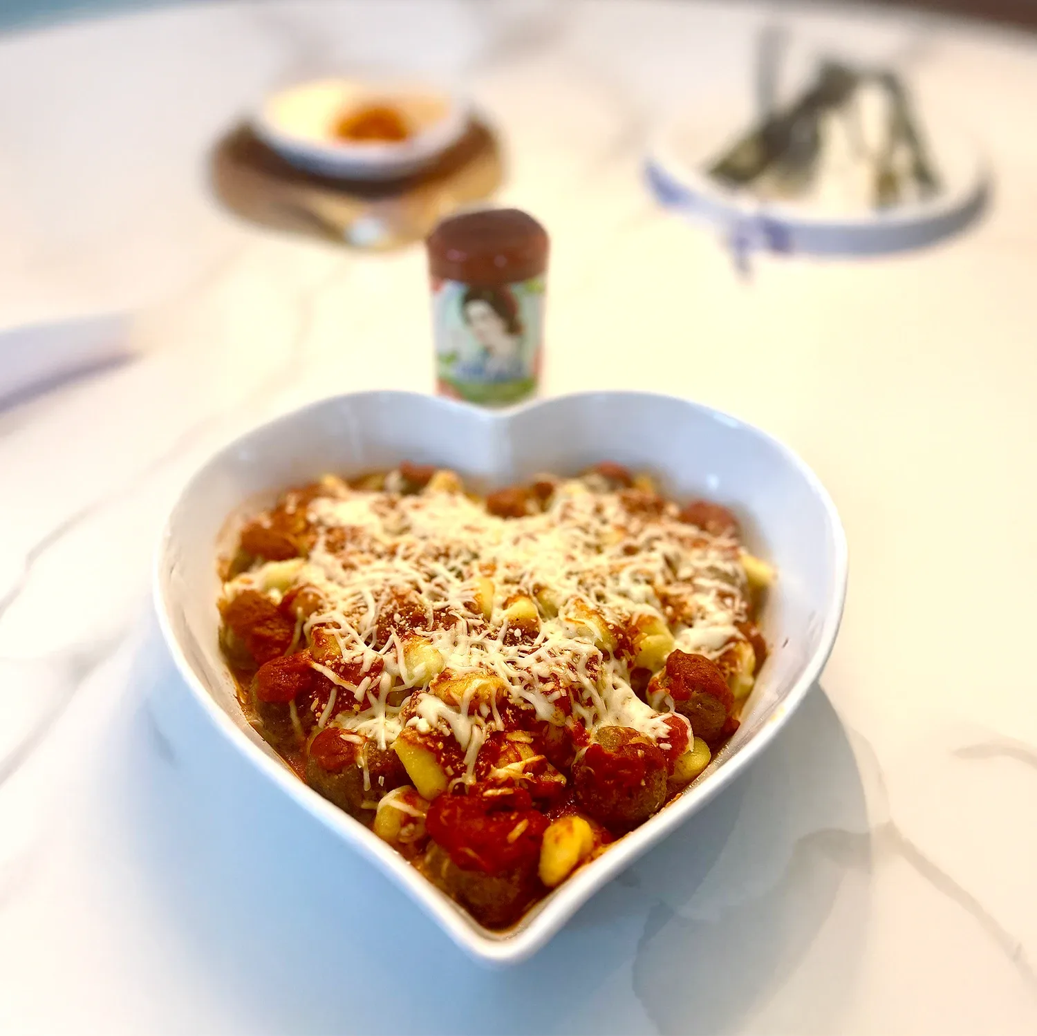 Bowl of gnocchi and meatballs in a heart-shaped bowl.