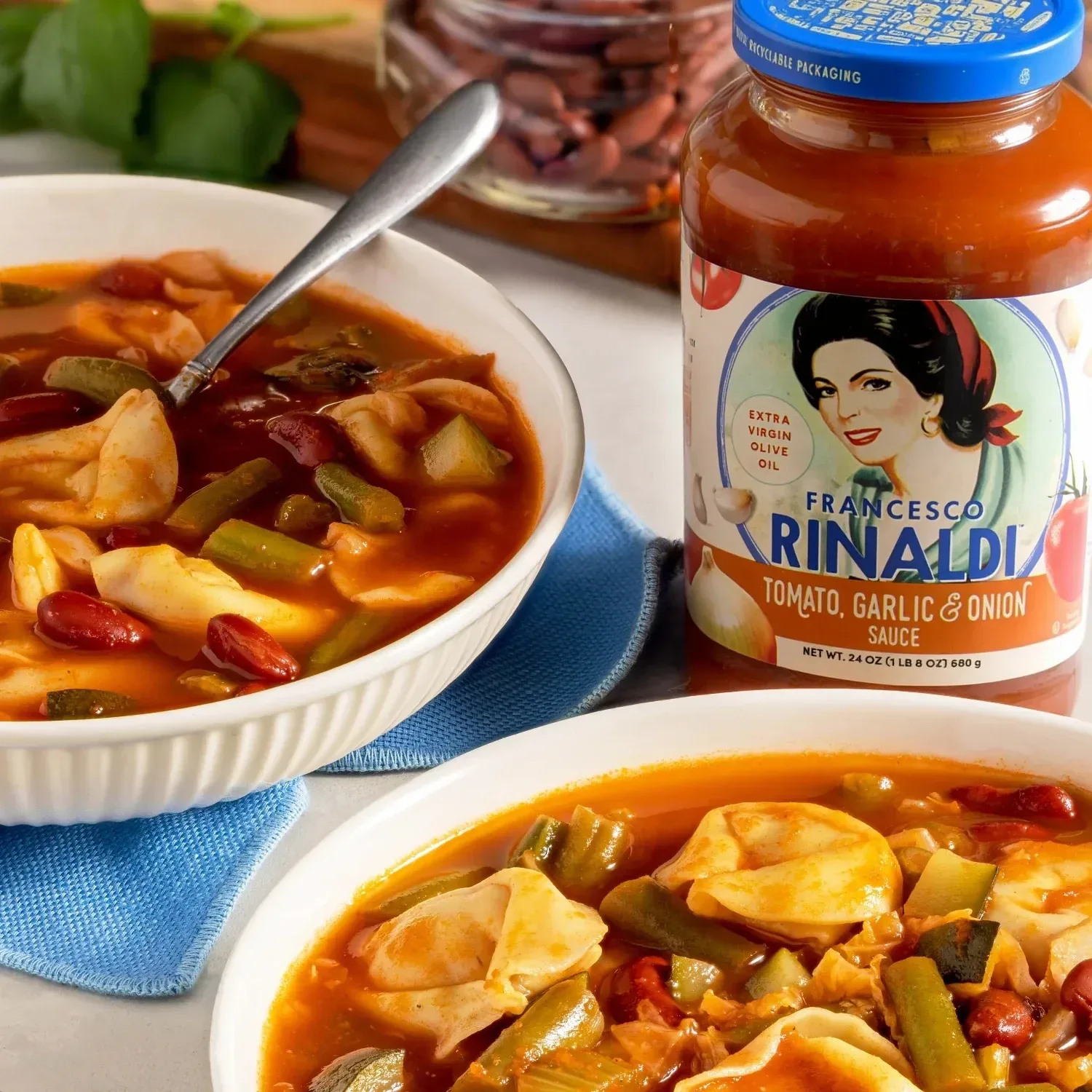 Bowls of Tortellini Minestrone Soup next to a jar of Francesco Rinaldi red sauce.